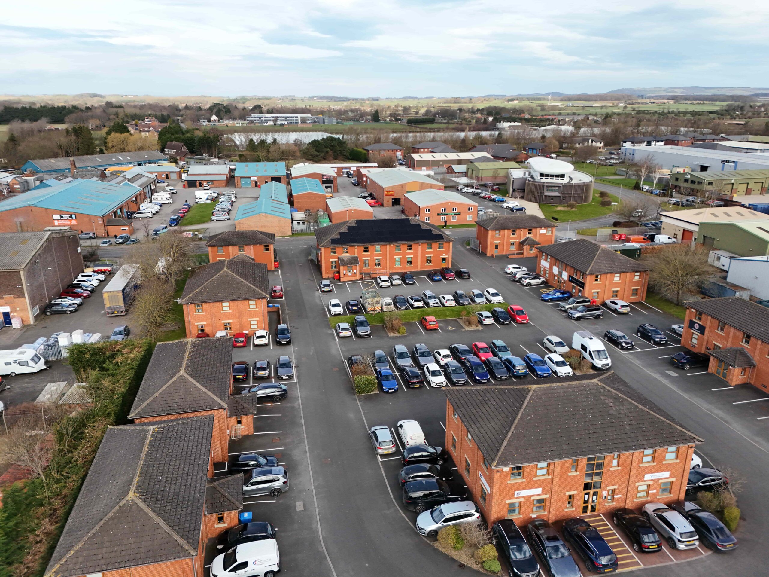 Aerial photograph of business park showing a combination of industrial units and office buildings with cars parked outside them
