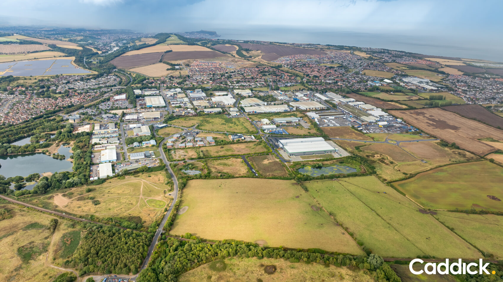 Aerial photograph of business units on an industrial estate with the sea in the background, taken on an overcast day.