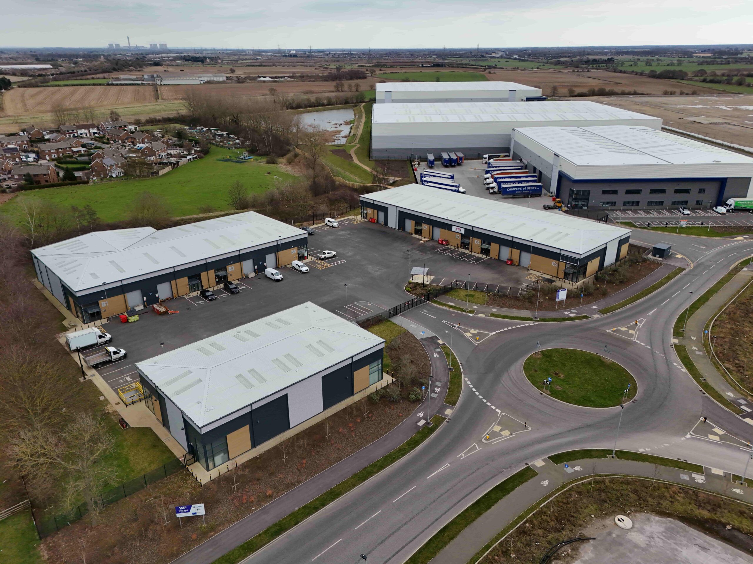 Aerial photograph of the Leeming Bar Industrial Site showing industrial units and traffic movements with green fields in distance