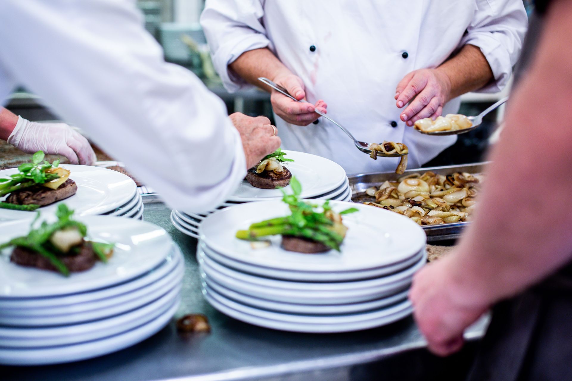 Chefs working on the pass in a busy restaurant kitchen